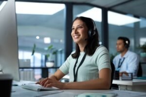 Woman using a headset while providing IT support on a computer