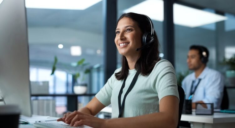 Woman using a headset while providing IT support on a computer